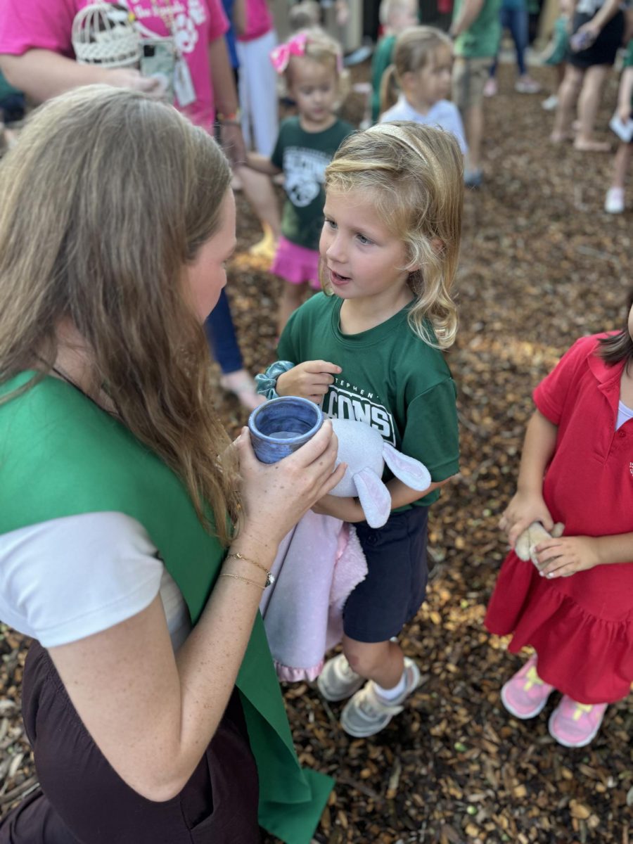 Student chaplain Ella Ziegler blesses a stuffed animal.