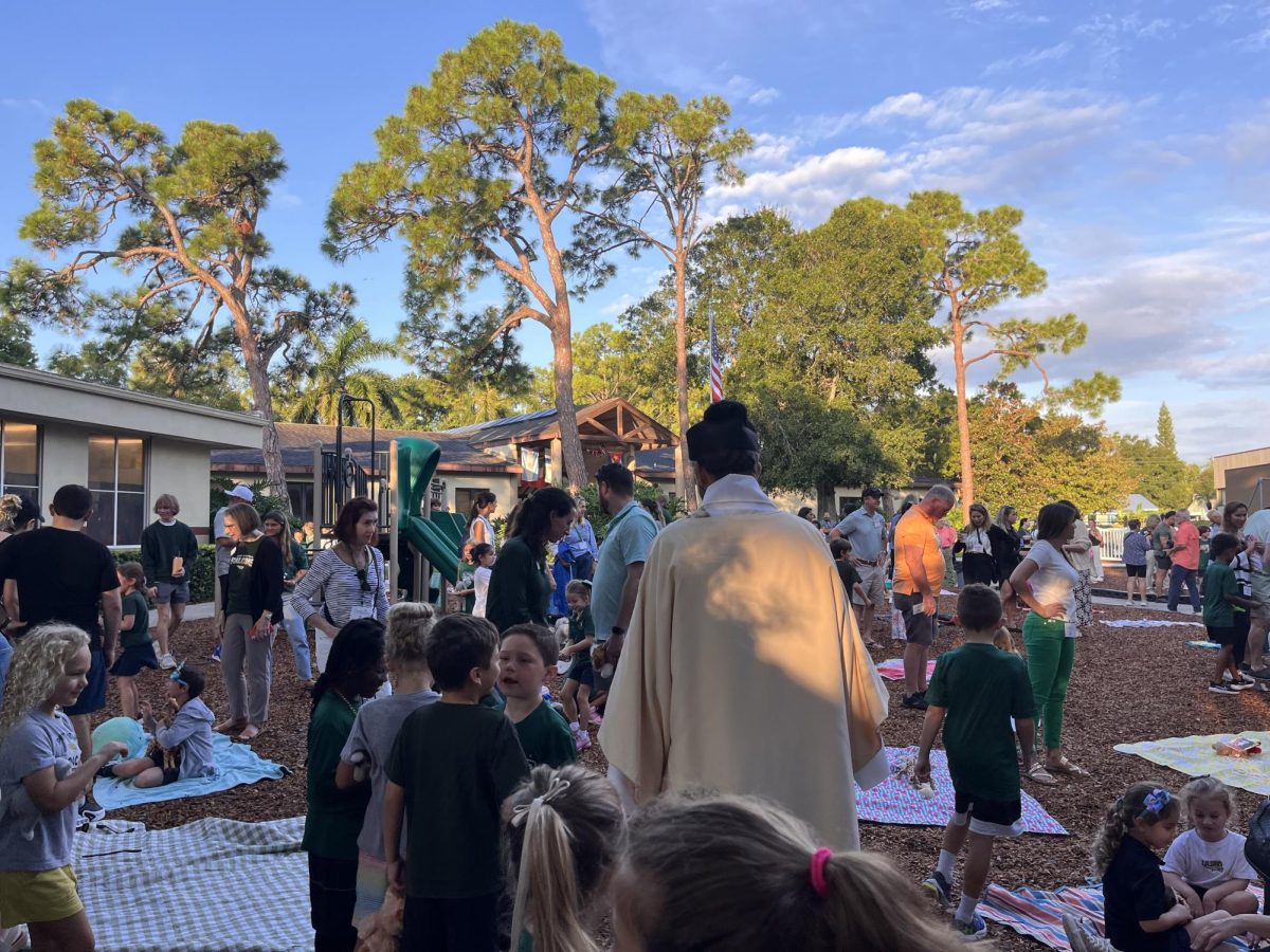 Friends and family gather around the playground to begin the Blessing of the Animals ceremony.