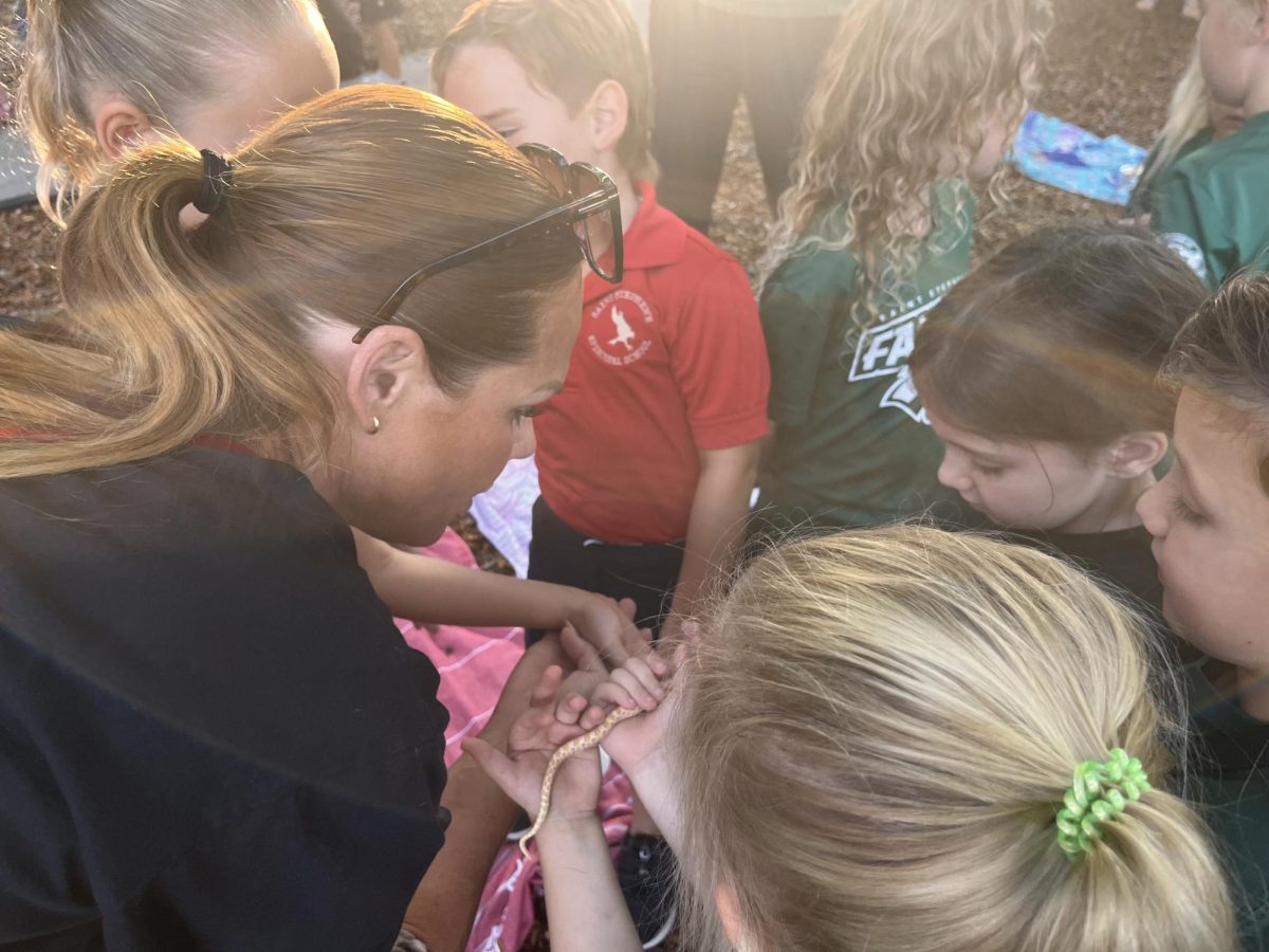 Students take turns in holding a pet snake.