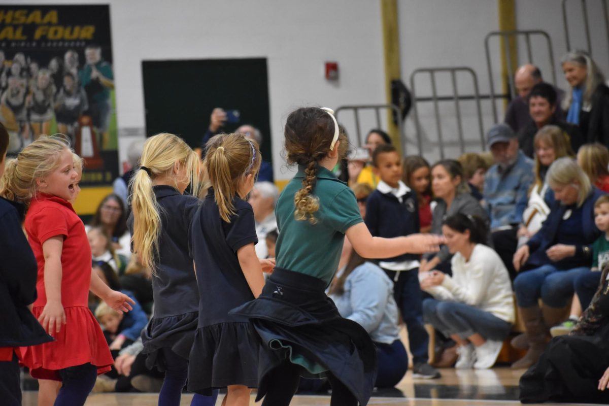 Lower School Falcons perform a fun dance as their grandparents watch from the stands.